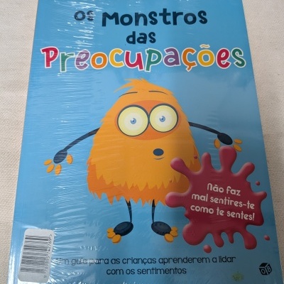 Capa de livro infantil azul com monstro laranja e texto colorido