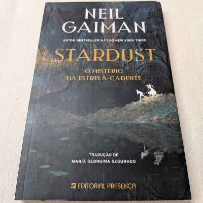 Livro Stardust de Neil Gaiman com capa ilustrada escura e detalhes dourados