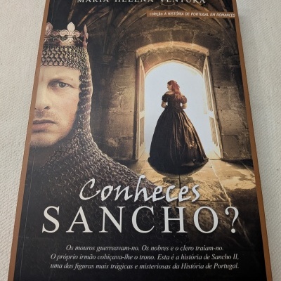 Capa de livro com homem com elmo e coroa e mulher vestida de época