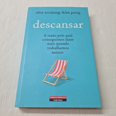 Livro com capa azul e imagem de cadeira de praia riscada rosa e branca