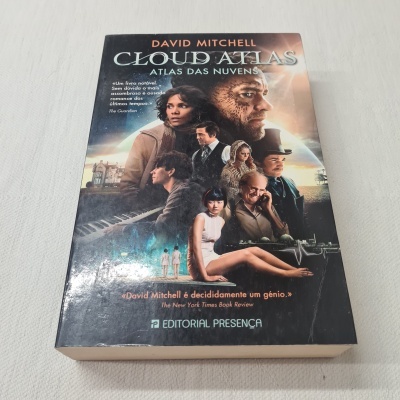 Capa do livro Cloud Atlas de David Mitchell com várias personagens e texto em português