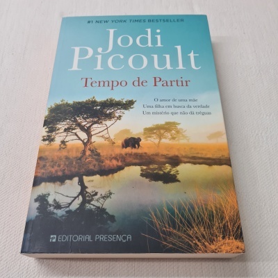 Livro Tempo de Partir de Jodi Picoult com capa azul e imagem de elefantes na natureza