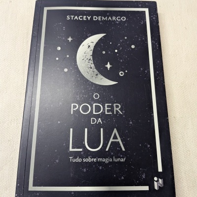 Capa de livro preto com lua crescente e texto O PODER DA LUA