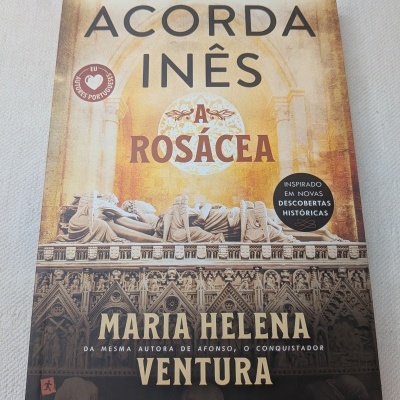 Capa de livro com título Acorda Inês A Rosácea de Maria Helena Ventura e imagem de escultura gótica.