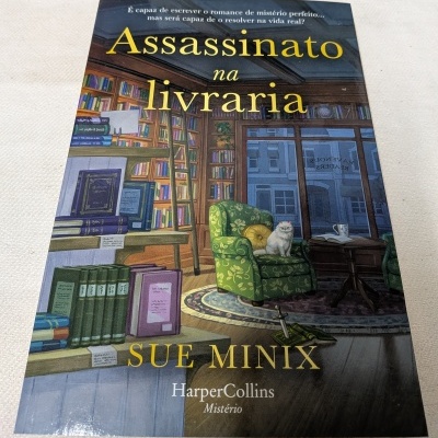 Capa de livro Assassinato na livraria com ilustração de livraria e gato