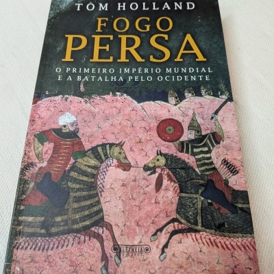 Livro Fogo Persa com capa ilustrada em tons vermelhos e pretos.