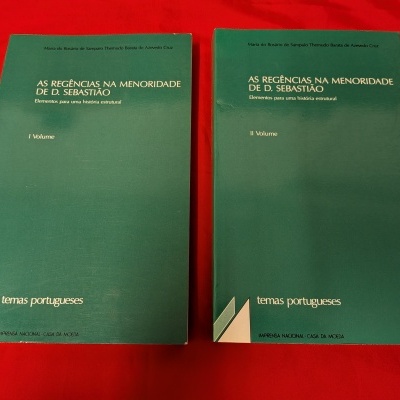 Dois livros verdes intitulados AS REGÊNCIAS NA MENORIDADE DE D. SEBASTIÃO volume I e II sobre fundo vermelho.