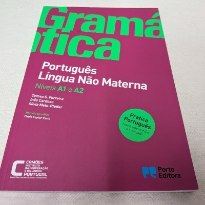Livro de gramática em capa rosa com texto verde e branco para aprender português, níveis A1 e A2