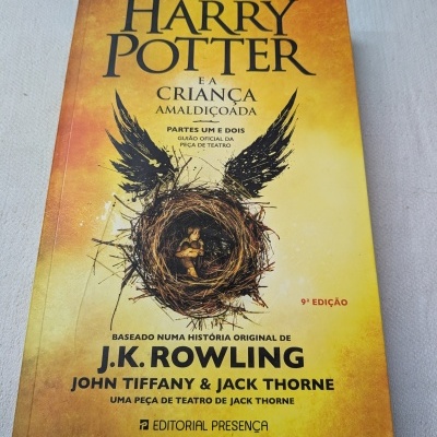 Capa do livro Harry Potter e a Criança Amaldiçoada com fundo amarelo e laranja