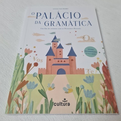 Capa de livro infantil com castelo rosa, flores e texto O PALÁCIO DA GRAMÁTICA