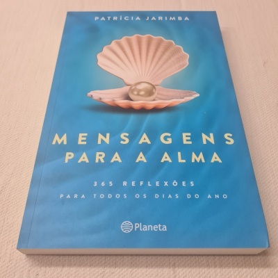 Capa de livro azul com ostra e pérola, título e autor visíveis.