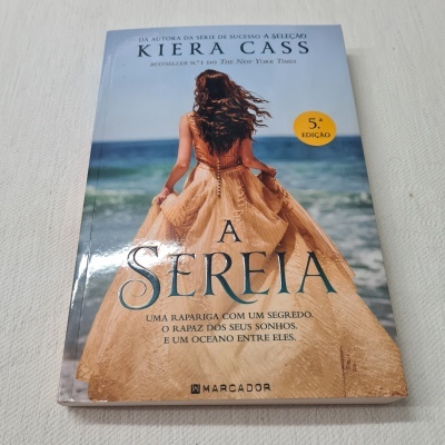 Capa do livro 'A SEREIA' de Kiera Cass com mulher com vestido à beira-mar