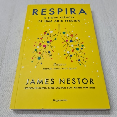 Livro amarelo com título RESPIRA e ilustracao de pulmões coloridos