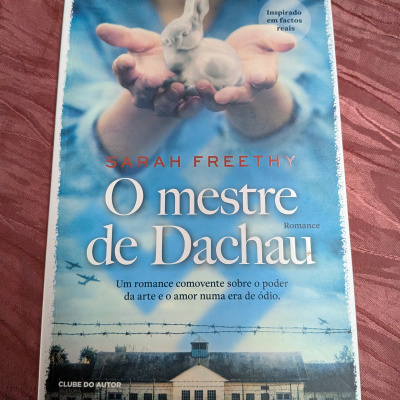 Capa de livro com mãos segurando figura branca de coelho e texto em azul e branco
