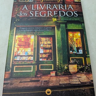 Capa de livro com fachada de livraria e título A LIVRARIA dos SEGREDOS