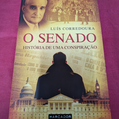 Capa de livro O Senado de Luís Corredoura sobre conspiração, com ilustrações históricas e homem de casaco preto
