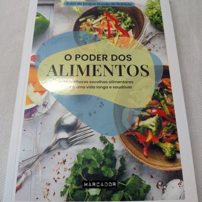 Capa de livro O PODER DOS ALIMENTOS com pratos de saladas e talheres sobre mesa clara.