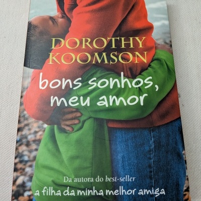 Capa de livro com pessoas de casacos vermelhos e verdes abraçadas e textos no título e autor.