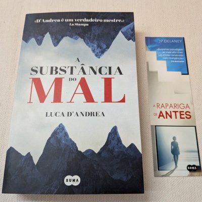 Livro 'A Substância do Mal' com ilustração de montanhas e marcador 'A Rapariga de Antes'