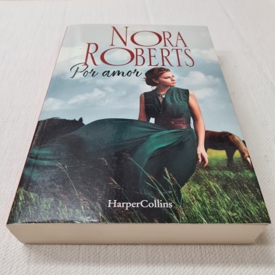 Capa do livro 'Por amor' de Nora Roberts com mulher de vestido verde e cavalo ao fundo