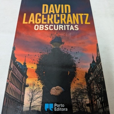 Capa de livro DAVID LAGERCRANTZ OBSCURITAS com homem de costas e céu ao pôr do sol.