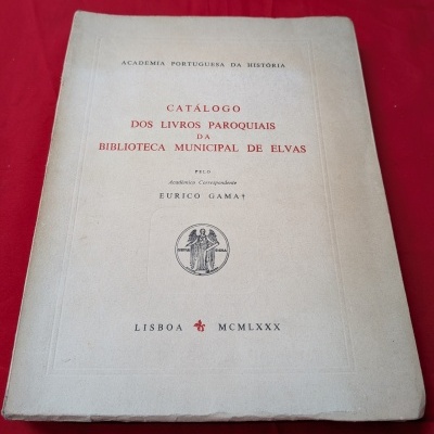 Livro catálogo dos livros paroquiais da biblioteca municipal de Elvas com capa bege e texto impresso em preto e vermelho.