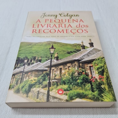 Capa do livro 'A Pequena Livraria dos Recomeços' com ilustração de casa rústica e vegetação.