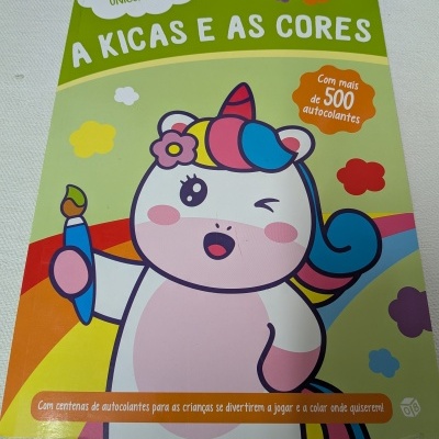 Capa de livro infantil com unicórnio branco e colorido segurando pincel e textos em português