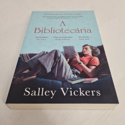 Capa de livro com mulher sentada num sofá a ler um livro