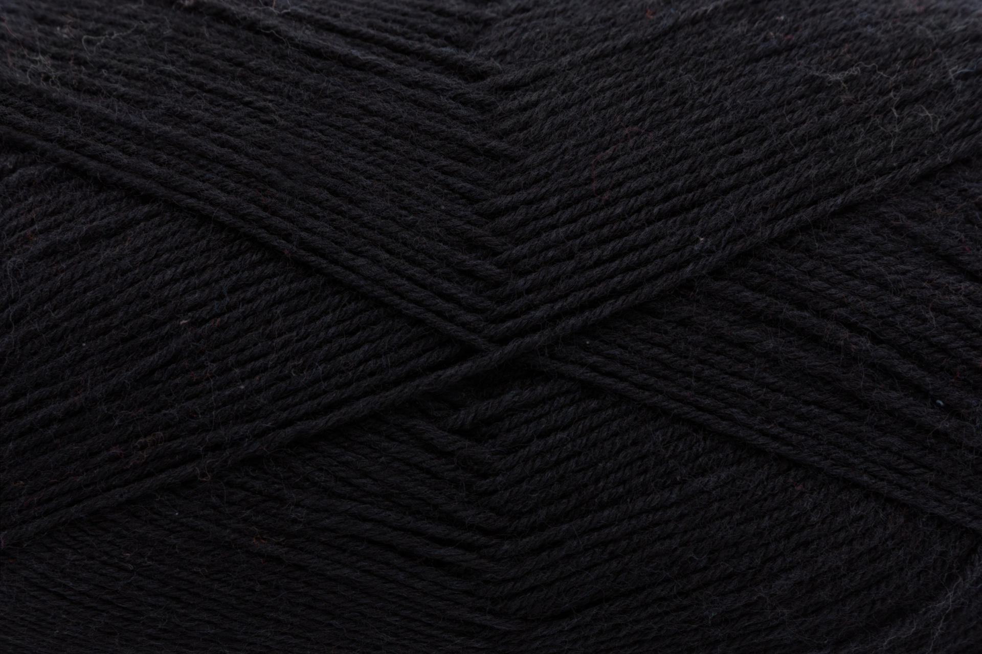 Novelo de lã preta com textura fina e entrelaçada