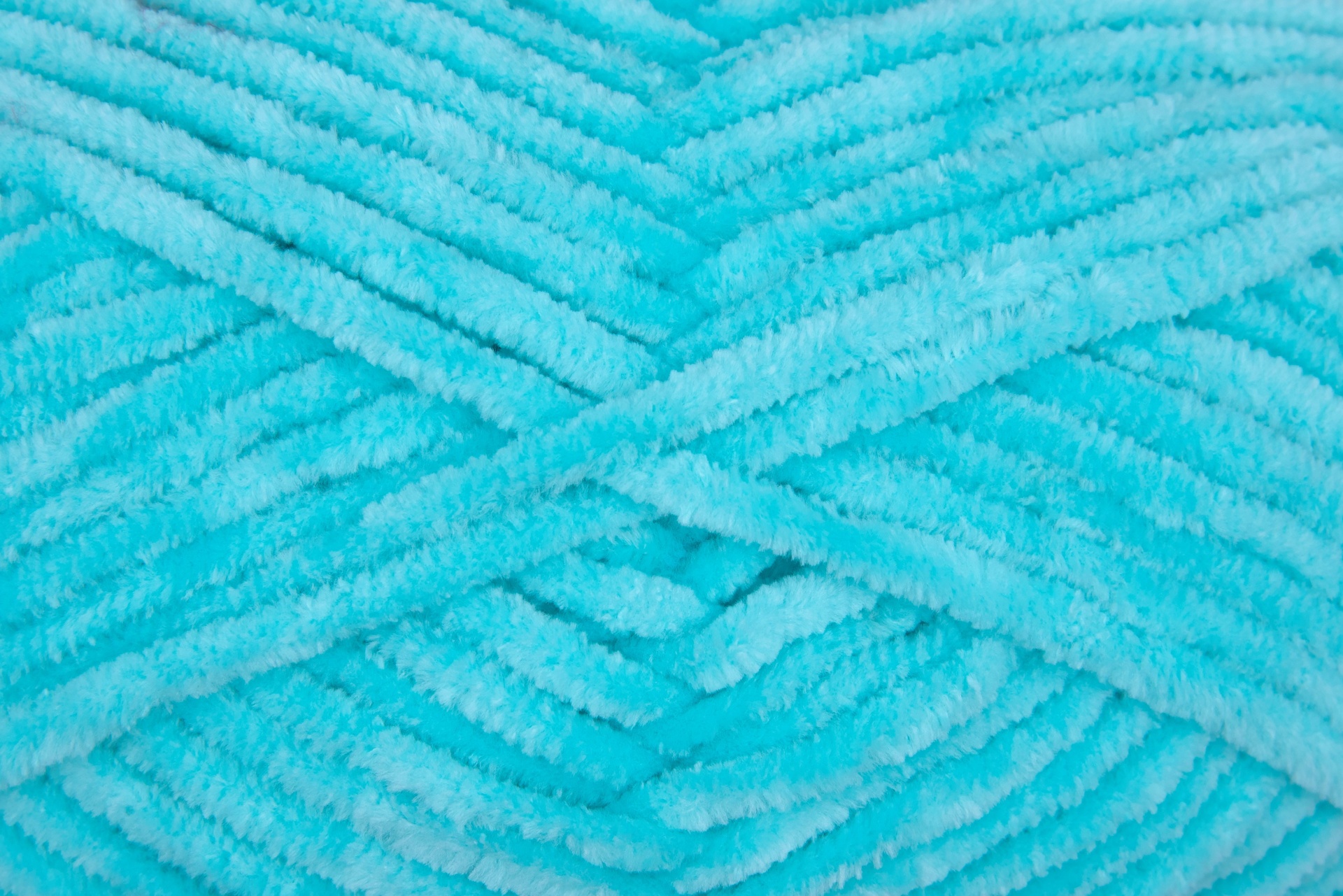 Novelo de fio felpudo azul turquesa com textura macia.
