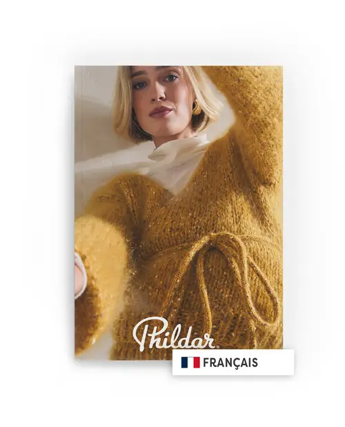 Mulher com suéter amarelo mostarda de malha com cordão, sobre blusa branca, fundo neutro, texto Phildar e FRANÇAIS