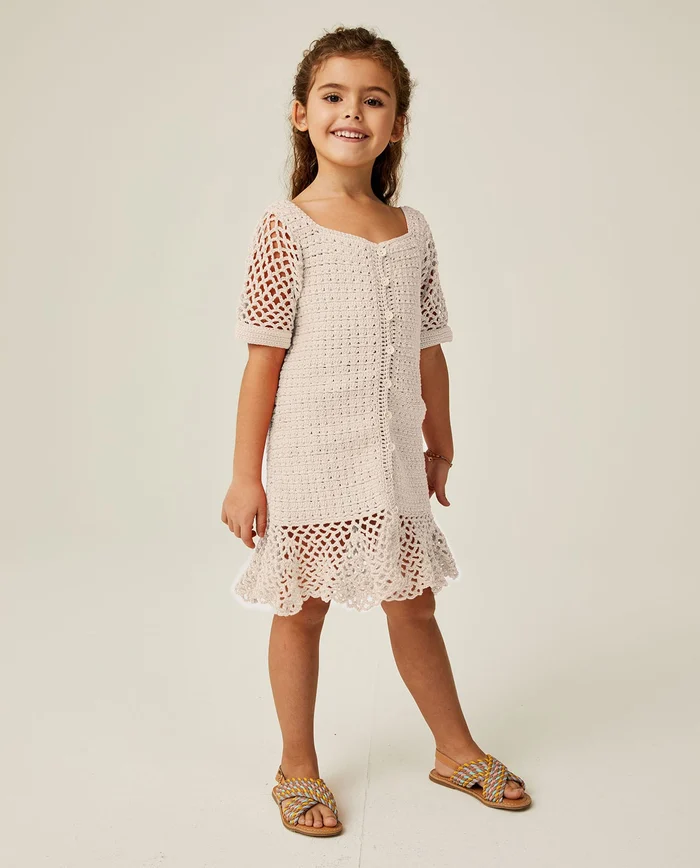 Vestido de crochê bege para criança com sandálias multicoloridas