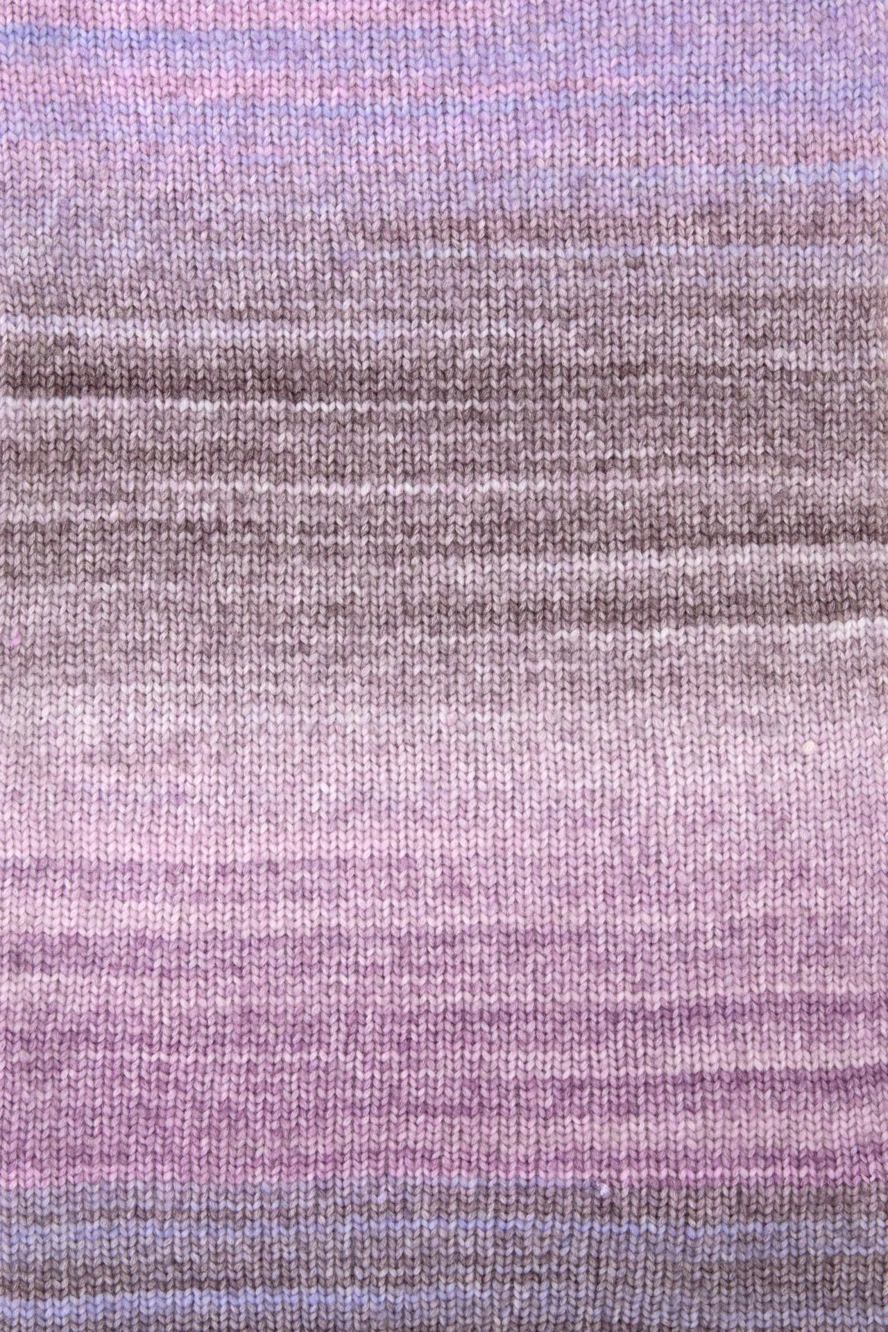 Pano de malha listrado em tons pastel de lilás, rosa e castanho claro
