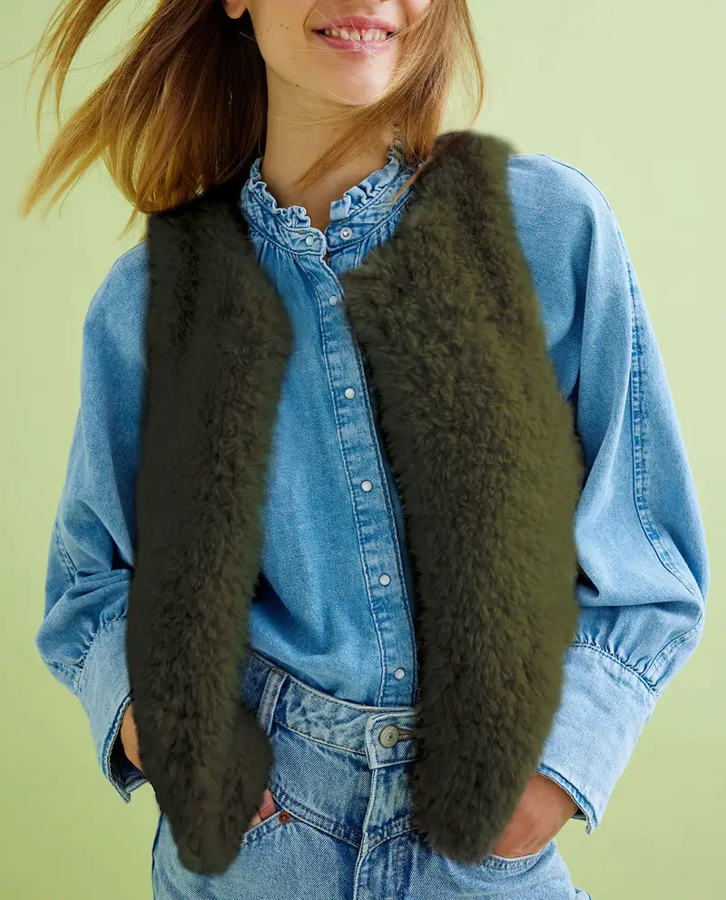 Colete verde escuro de pelúcia sobre camisa jeans azul clara com gola de babados