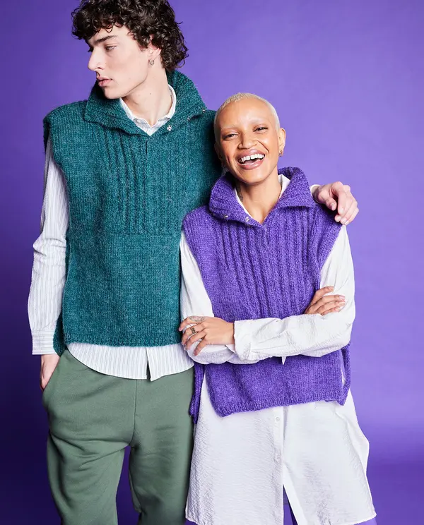 Dois modelos com coletes de malha verde e roxo sobre camisas brancas, fundo roxo