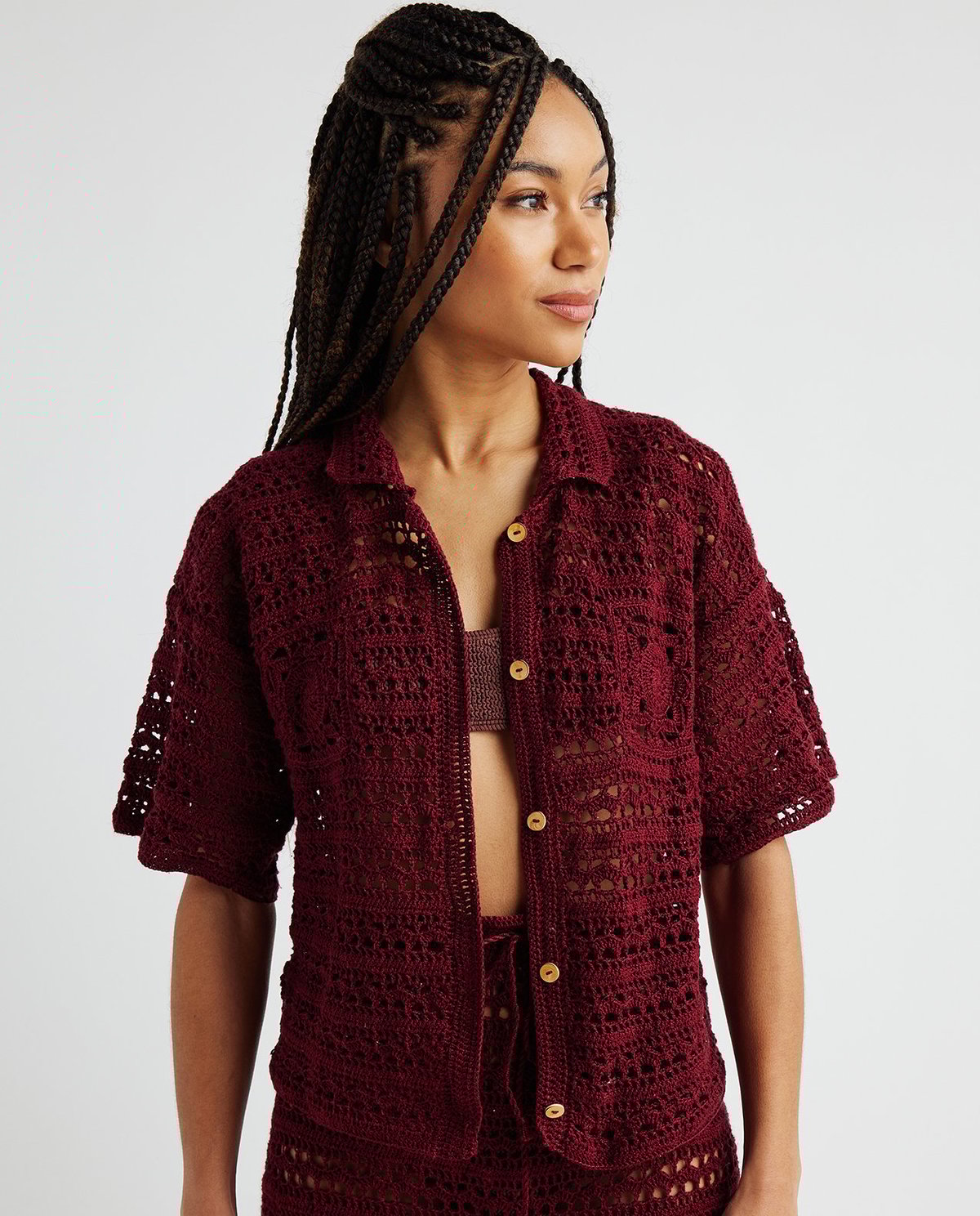 Camisa de malha crochetada bordô com botões amarelos e gola tradicional.