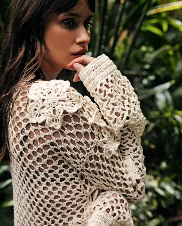 Camisola de malha crochet creme com padrão aberto e flores nos ombros, vista lateral