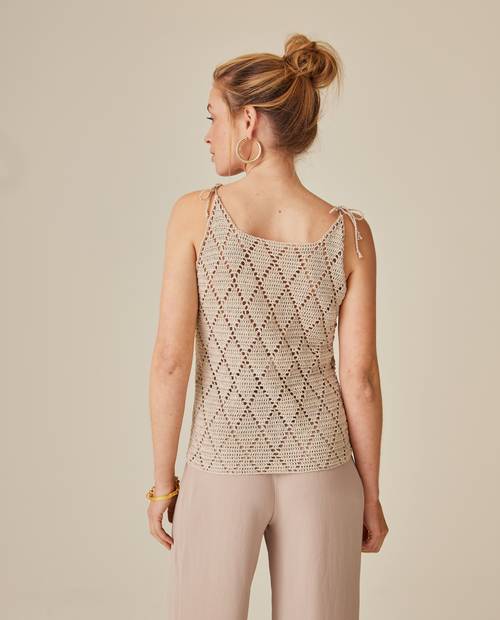 Top de malha bege com padrão de losangos visto de costas