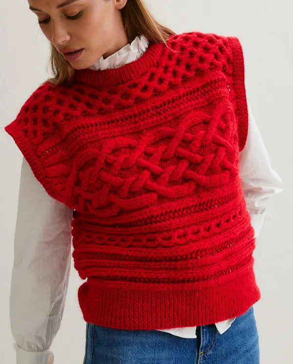 Colete vermelho de malha texturizada usado sobre camisa branca