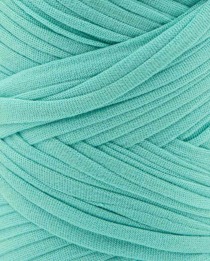 Novelo de fio azul claro tricotado com padrão entrelaçado