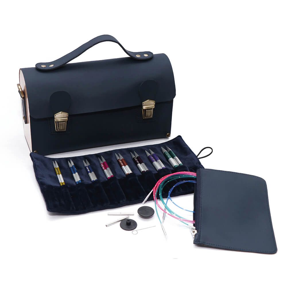 Bolsa preta de couro com fivelas douradas, canetas coloridas e estojos em veludo azul