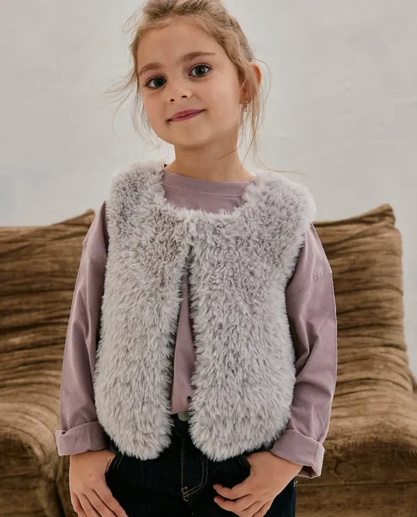 Criança vestindo colete de pelúcia cinza claro e t-shirt manga comprida roxa clara