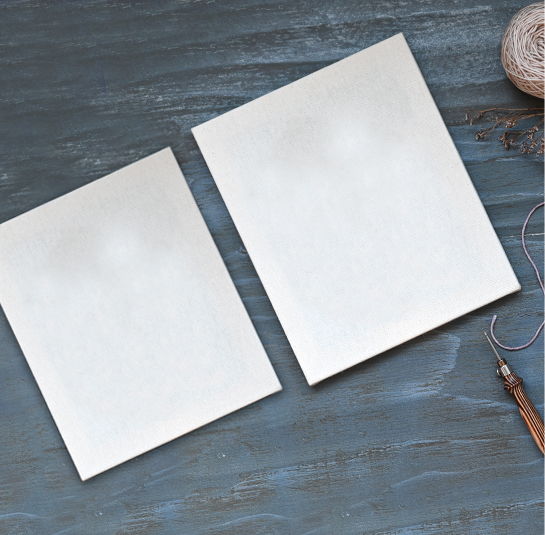 Dois cadernos ou agendas brancos sobre superfície azul escura com novelo de linha e pena decorativa