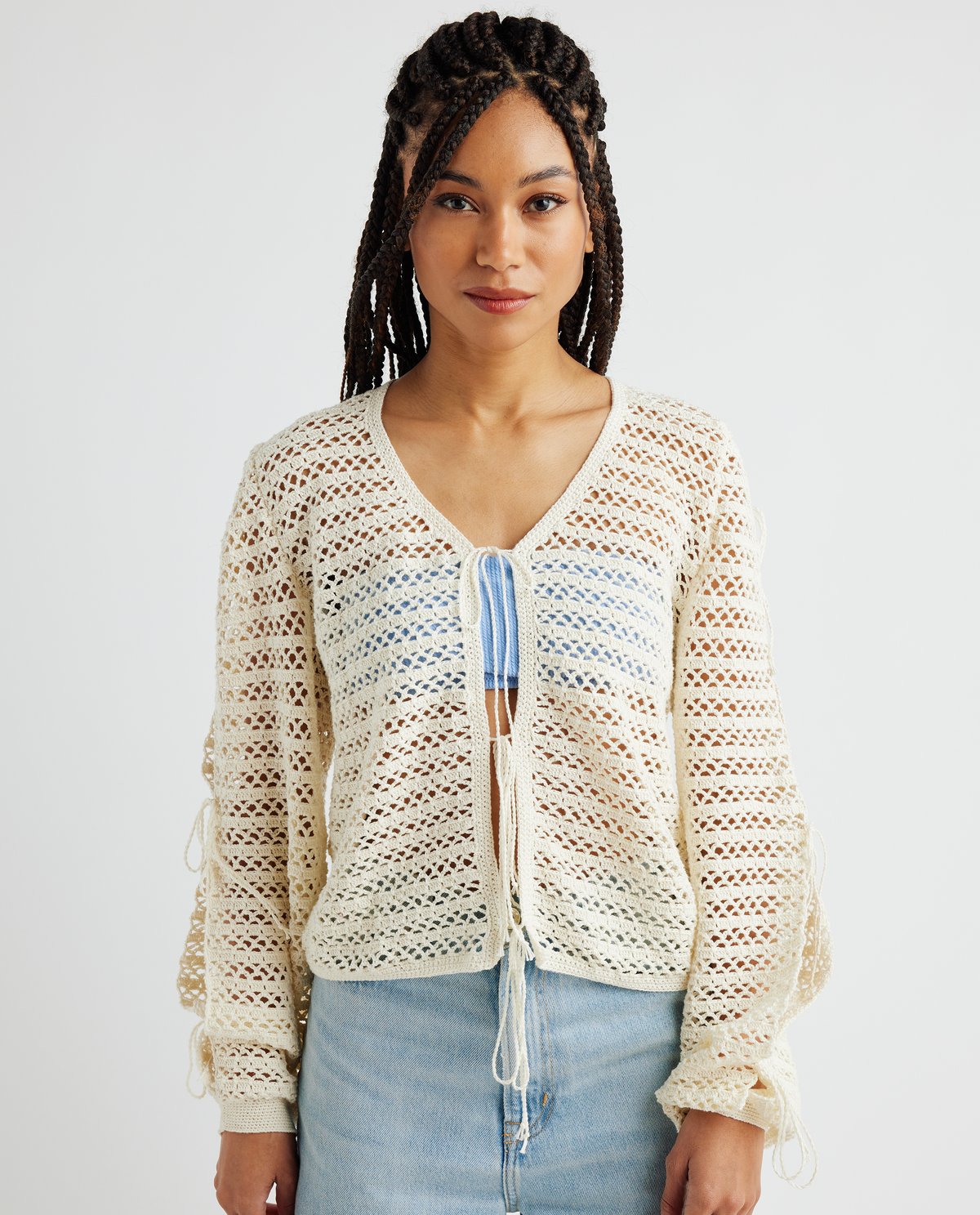 Camisola de malha aberta creme com cordões frontais e nas mangas