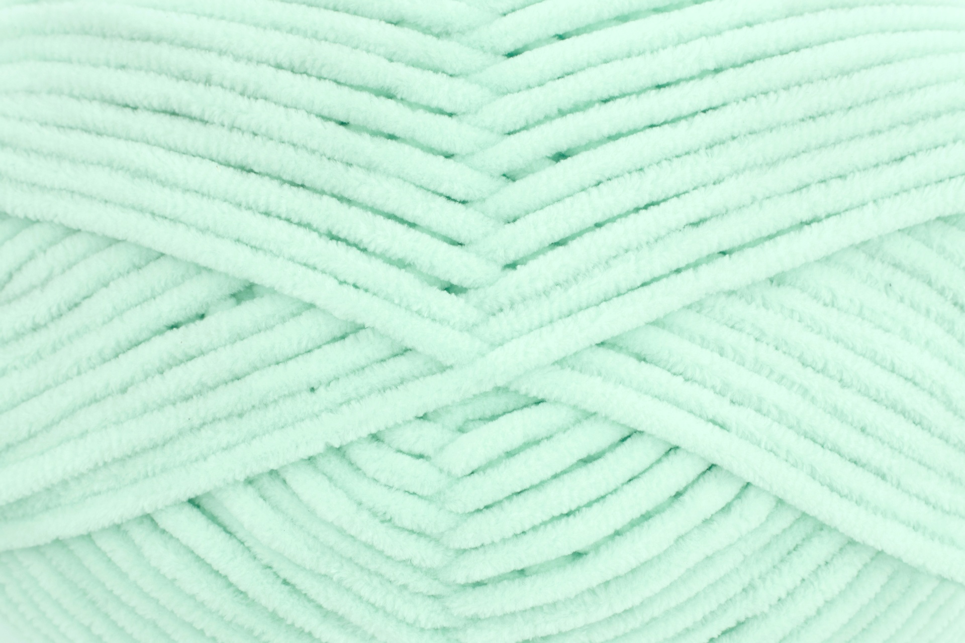 Novelo de fio de malha verde-água claro com textura felpuda