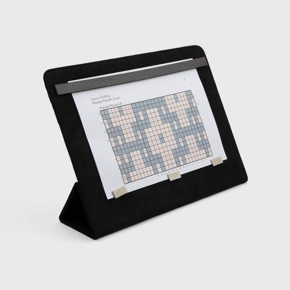 Suporte preto para folhas A4 com padrão quadriculado colorido fixado por imãs