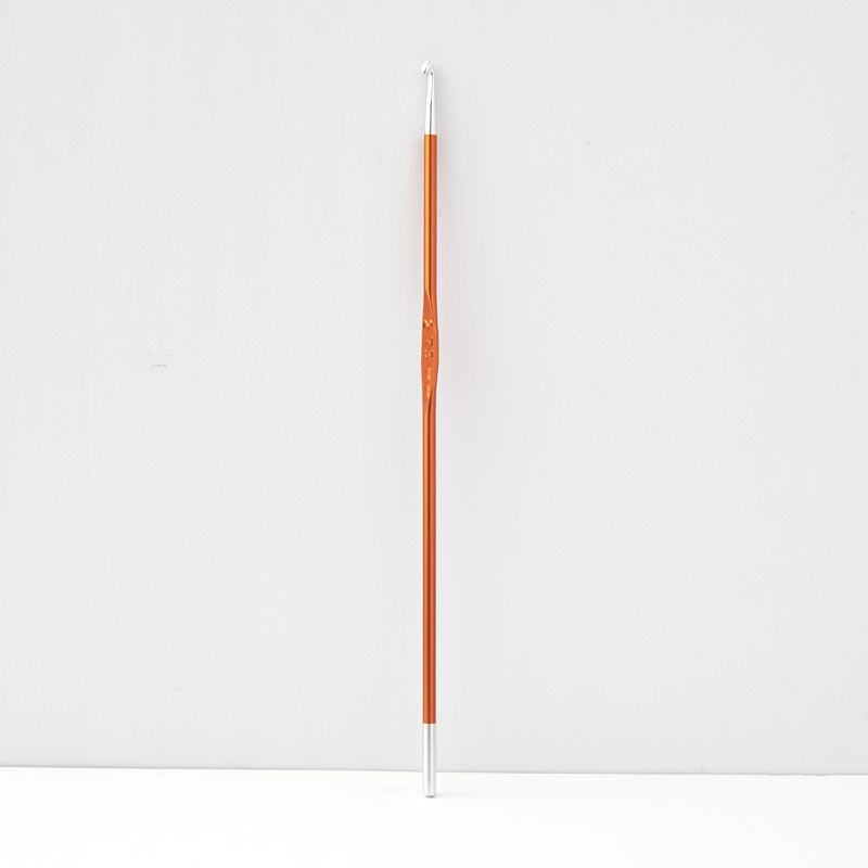 Instrumento de madeira laranja com ponta curva branca e extremidades metálicas