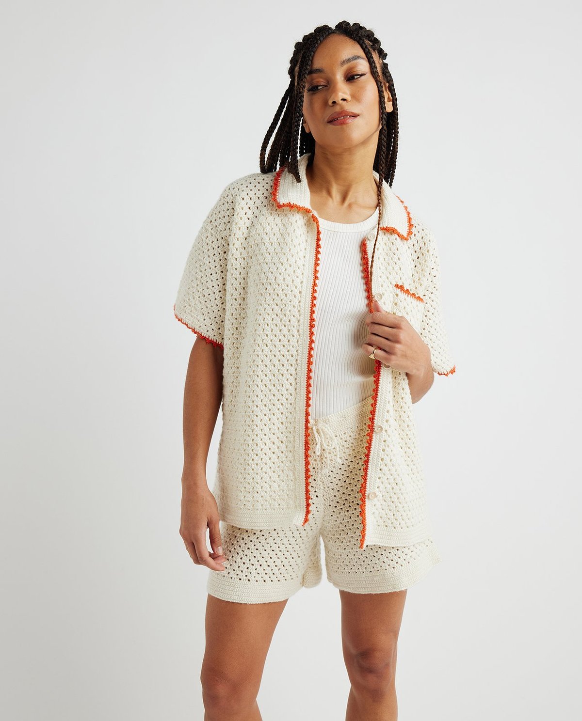 Conjunto feminino de malha creme com bordas laranja e calções de crochê