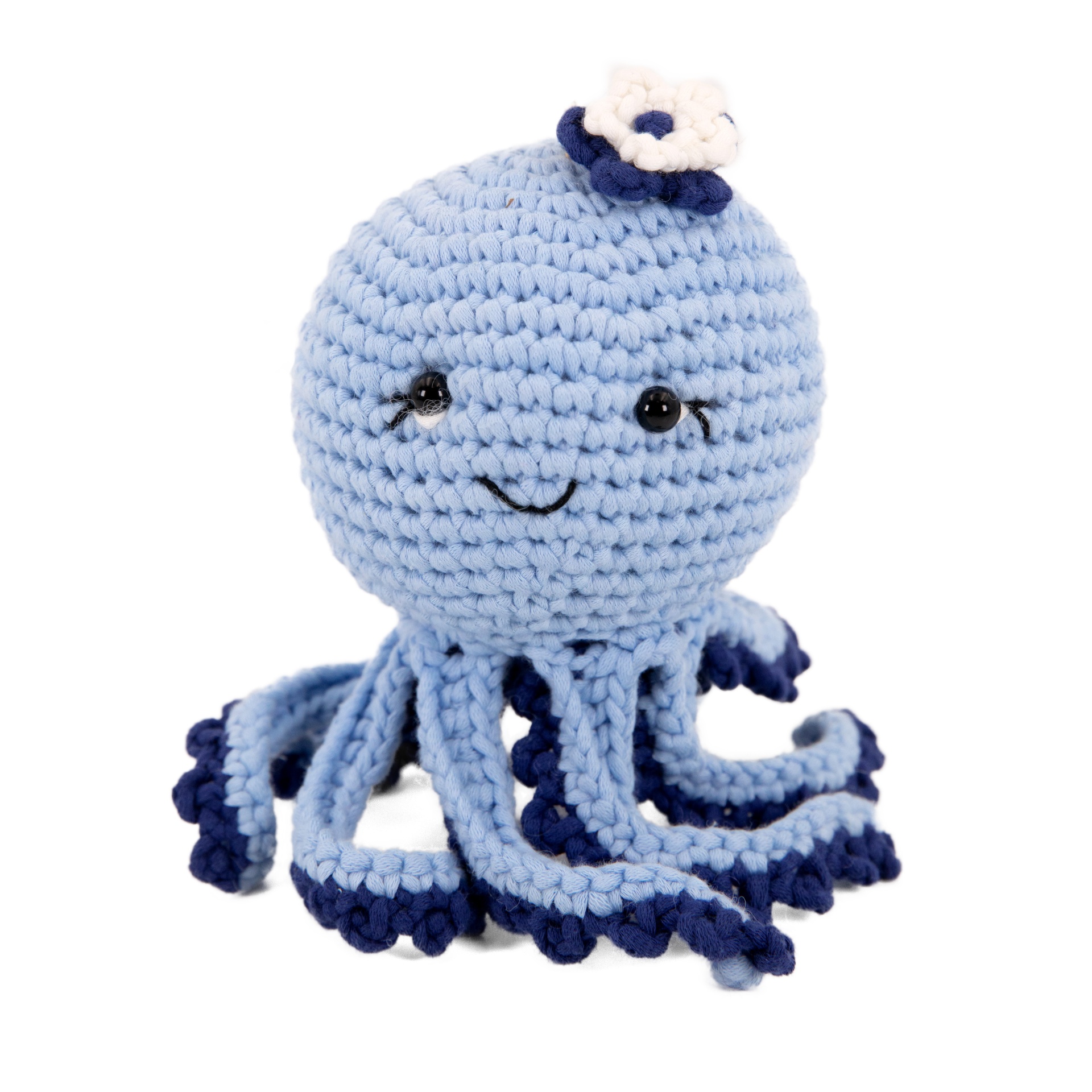 Boneca de amigurumi azul clara com flor em crochê e olhos pretos